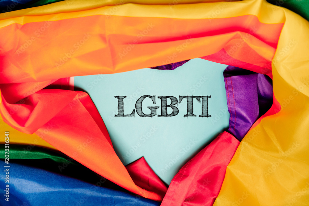Fototapeta premium LGBTI Text Surrounded by Rainbow Flag Fabric