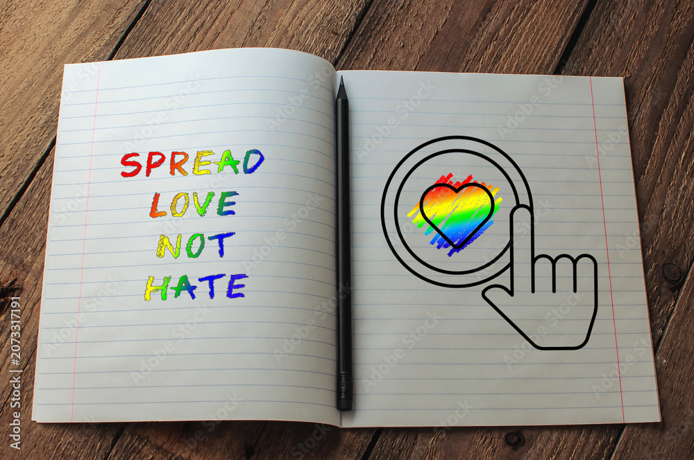 Naklejka premium Notebook with Rainbow Text and Heart Symbol on Wooden Table