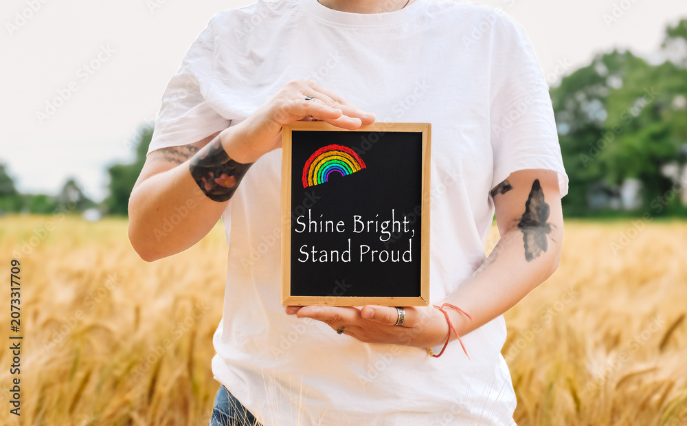 Fototapeta premium Person Holding Chalkboard with Rainbow Message in Wheat Field