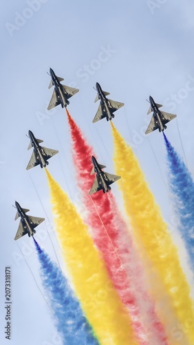 Fighter jets in formation with colorful smoke trails during air show