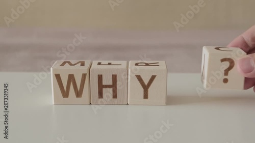 motivational word why ?, laying out  by hand from letters on wooden cubes, slow motion
