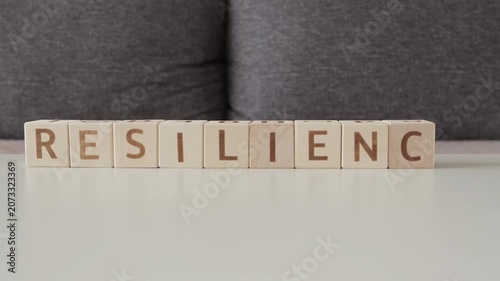 motivational word resilience, laying out  by hand from letters on wooden cubes, slow motion
