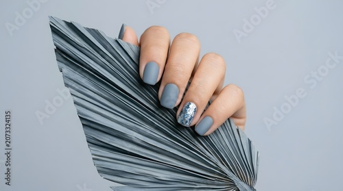 Matte Blue Gray Nail Art with Silver Glitter Accent on Dried Palm Leaf Minimalist Beauty Background