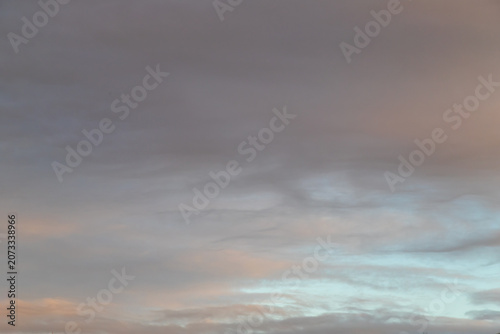 Soft pastel clouds drift across a calm sky at sunrise, creating a tranquil, moody atmosphere ideal for backgrounds, landscapes, weather concepts and peaceful nature imagery.