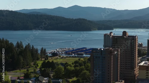 Aerial of coeur dAlene waterfront resorts with marina and mountains on lake in summer at sunset