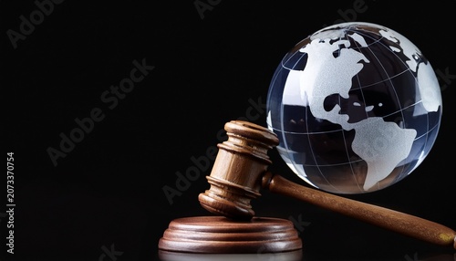 symbol of international justice showing a wooden judge s gavel and glass globe on black background with copy space