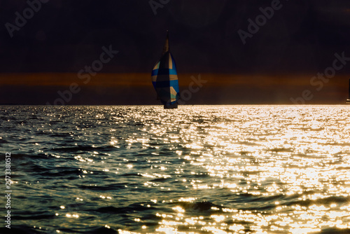 Vintage sailing boat through splashing water at sunset, Sailing regatta in the Gulf of Finland at sunset, hot race of several yachts, teamwork