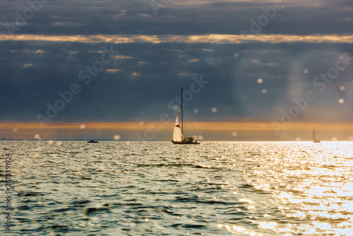 Vintage sailing boat through splashing water at sunset, Sailing regatta in the Gulf of Finland at sunset, hot race of several yachts, teamwork