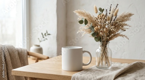 Cozy interior scene with white mug and vase of dried flowers on wooden table