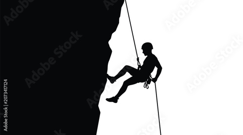 A silhouette of a professional climber descending a steep mountain cliff using a secure rope system