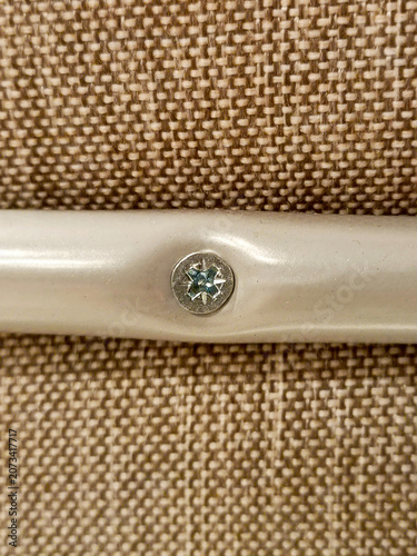 Fastening furniture parts. Close-up of a screw being tightened. Vertical photograph.
