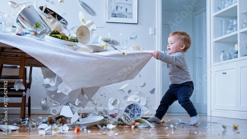Mischievous Toddler Boy Pulling Tablecloth Causing Flying Dishes and Food Mess in Dining Room