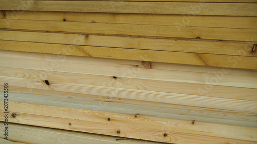 Horizontal stack of natural pine wood planks and lumber