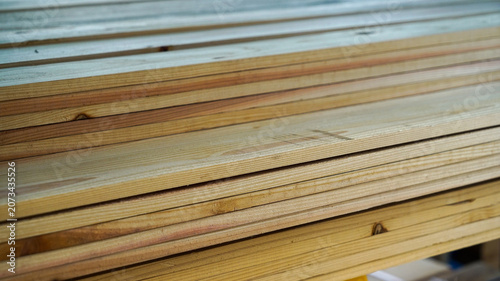 Horizontal stack of raw pine wood planks and lumber