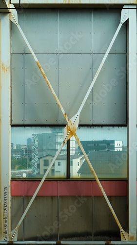 Industrial steel X bracing structure on a platform wall inside a Japanese subway station