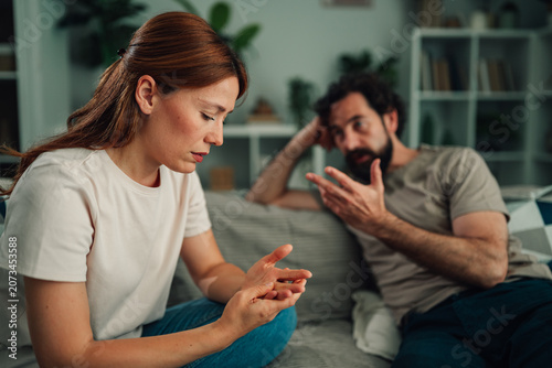 Konstfotografi Couple having conflict at home, woman feeling stressed and sad, man talking aggr