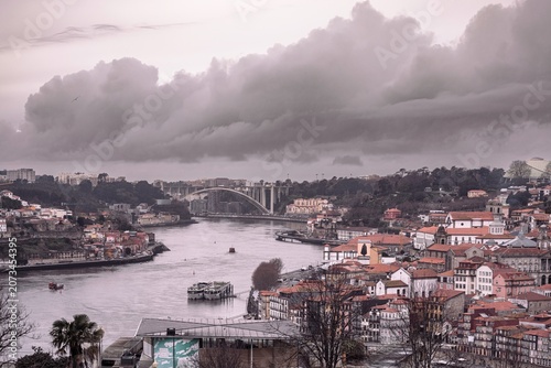 A breathtaking view of Porto’s skyline reveals the harmonious blend of old and new, with the Douro River reflecting the impending storm