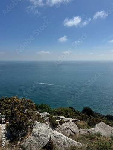 Foto Vista panorâmica sobre o oceano a partir de uma falésia, horizonte infinito sob céu azul com poucas nuvens