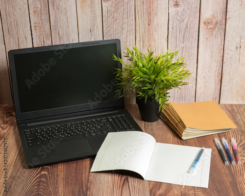 opened notebook markers notebooks and laptop on wooden table
