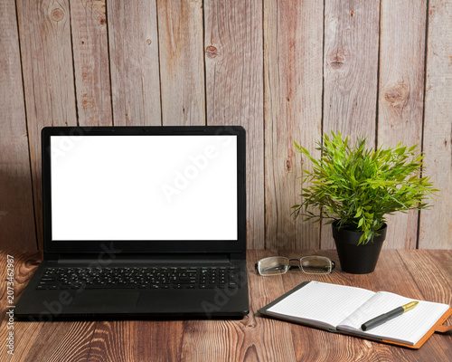 laptop with white monitor notebook glasses and pen on table
