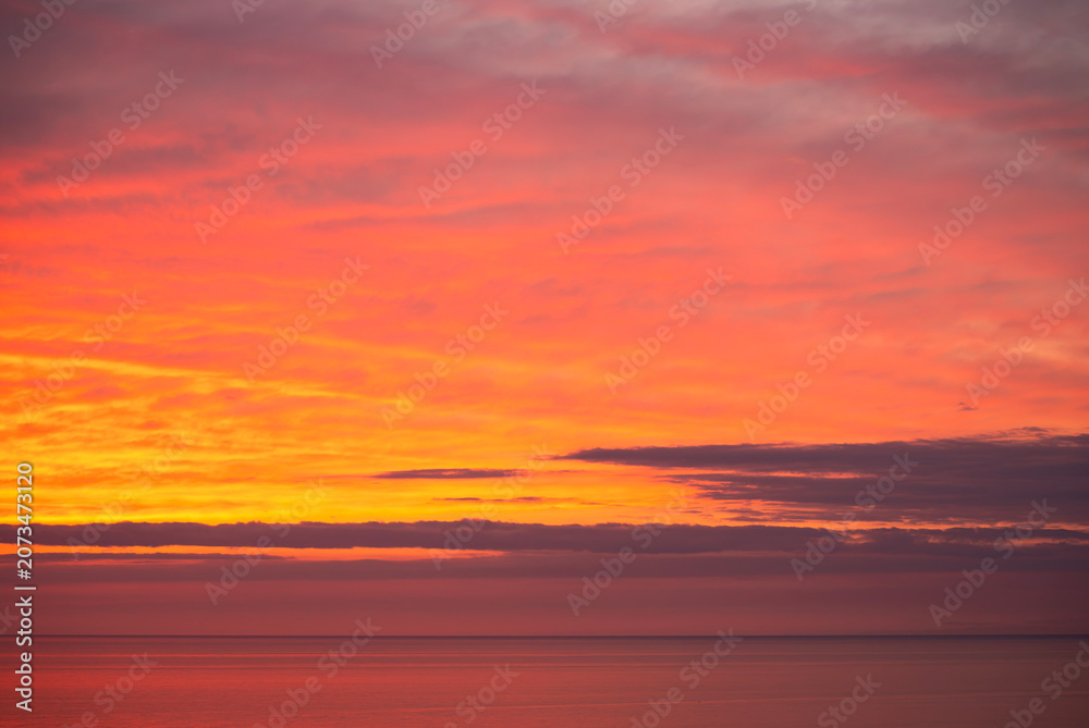 Fototapeta premium Beautiful orange sunset over the sea. Evening sea landscape