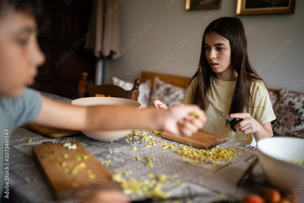 Fototapeta premium Children preparing food together at kitchen table