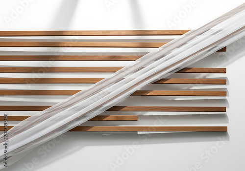 Abstract wood slats with flowing white fabric against a wall during soft daylight