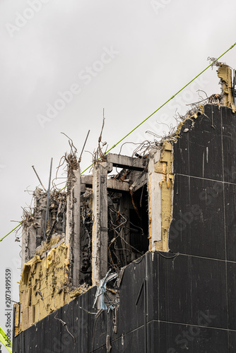 Partially demolished concrete building structure with exposed rebar.