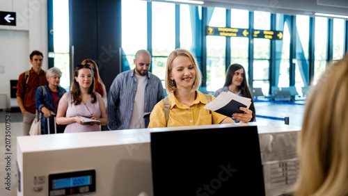 Check-in process at airport with travelers waiting in line at counter
