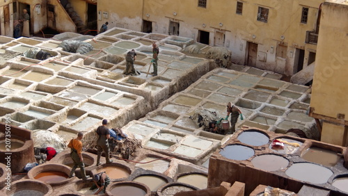 Fotografie Workers at the square chemical vats for softening leather at the Chouara Tannery