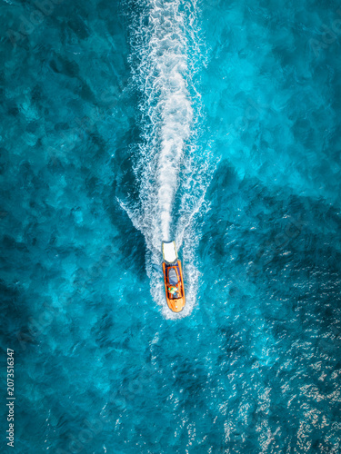 Foto Aerial top down view of orange jet ski moving fast in turquoise ocean water in Mallorca, Spain