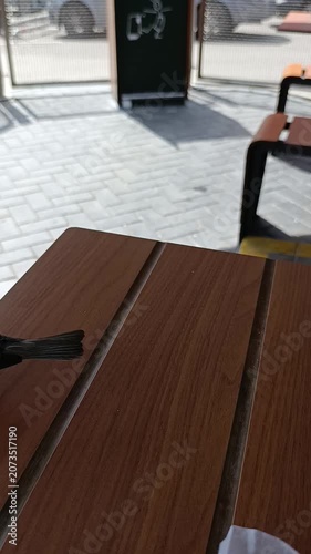 A sparrow is pecking at crumbs from a table in a café.