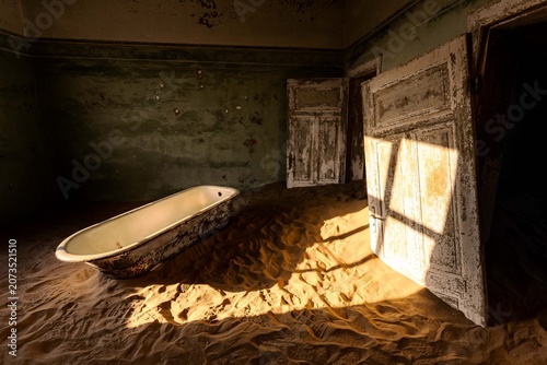 Canvastavla Sunrise in Kolmanskop, doorframe and bathrub buried by sand in an old mining tow