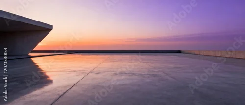 Panel kuchenny z motywem A stunning sunset view featuring a modern concrete structure with the sea reflecting the vibrant colors of the sky.