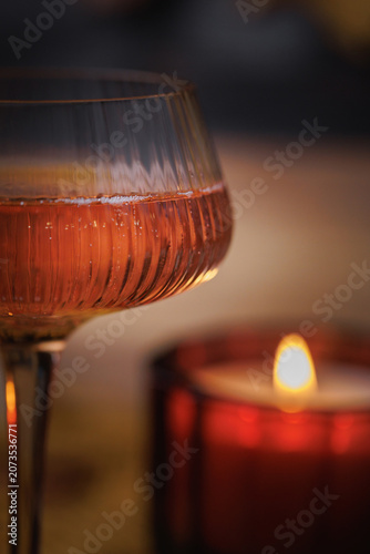 Textured glass with Rose wine near lit candle in soft warm autumn atmosphere
