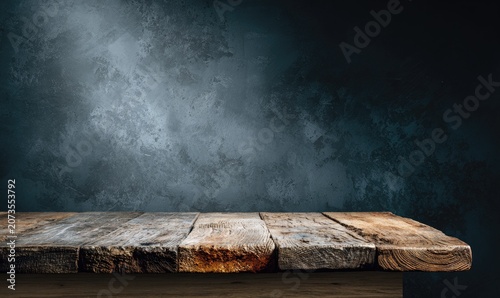A rustic wooden surface sits prominently in the foreground, contrasted against a textured, dark blue-gray wall, creating a moody and industrial aesthetic.