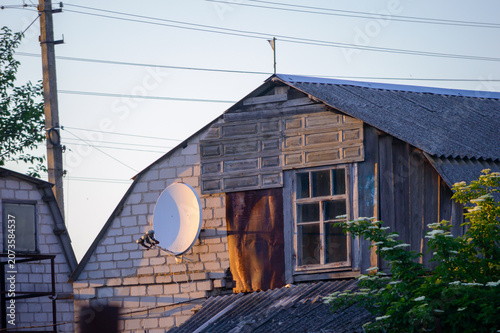 old wooden house with a satellite dish