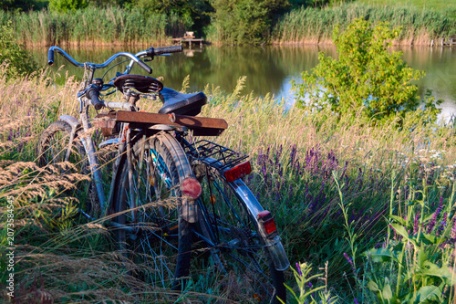 two bicycle in the grass with lake background