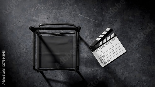 Film director chair and clapperboard on dark background