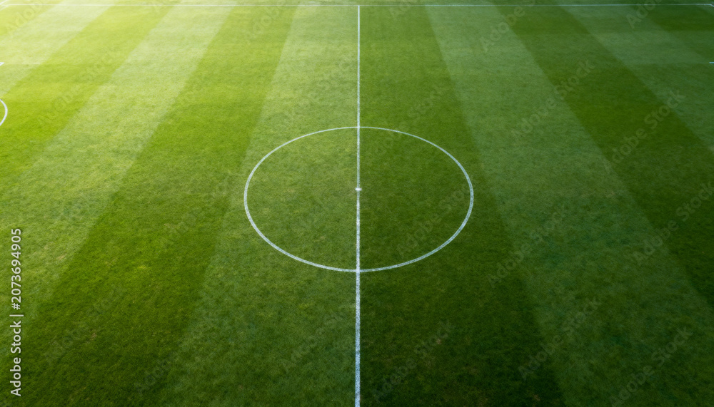 Obraz premium Top down football field background, aerial green pitch with center circle lines, football and soccer wallpaper, stadium banner, sports poster design, wide 16:9 image with copy space