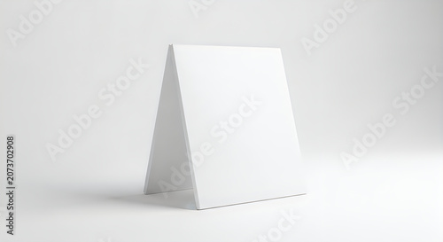 Blank white table tent card mockup standing on clean bright studio background.