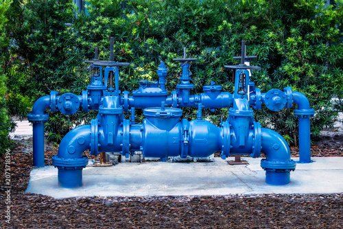 Front view of large commercial blue double check valve assembly and backflow preventer system on concrete pad