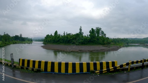 4K shot of Ambica river flowing besides the road as seen from a vehicle during the monsoon season on the way towards Saputara in Gujarat, India. Scenic natural background with copy space.
