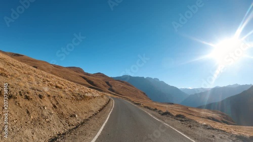 4K POV shot of a vehicle moving on a road in the dry Himalayan mountains during the summer season on a day with clear sky as seen near Hikkim village in Spiti Valley, Himachal Pradesh, India.