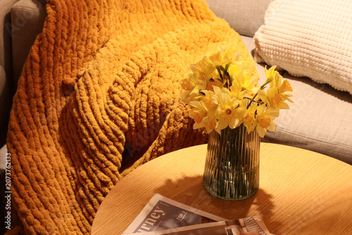 Soft plaid on sofa and bouq...