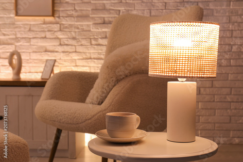 Glowing lamp with cup of co...