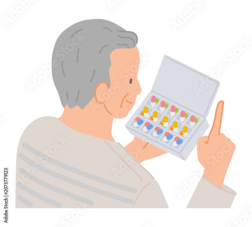 Senior man checking pill organizer at home