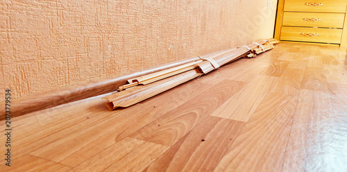 Canvastavla A bundle of baseboards on the floor in the room; requires repair.
