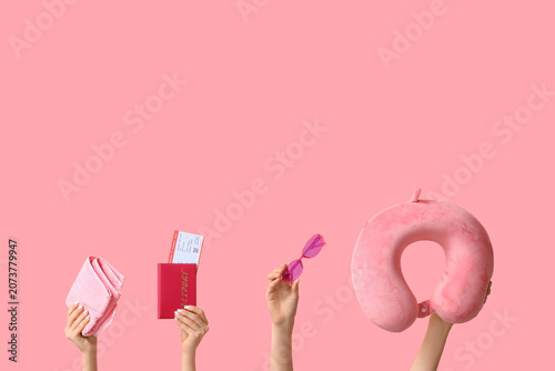 Female hands with beach accessories on pink background. Tourism concept