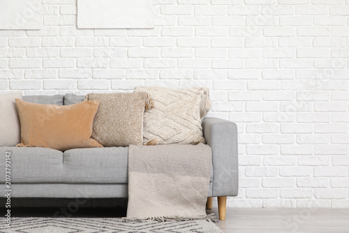 Grey sofa with cushions and...